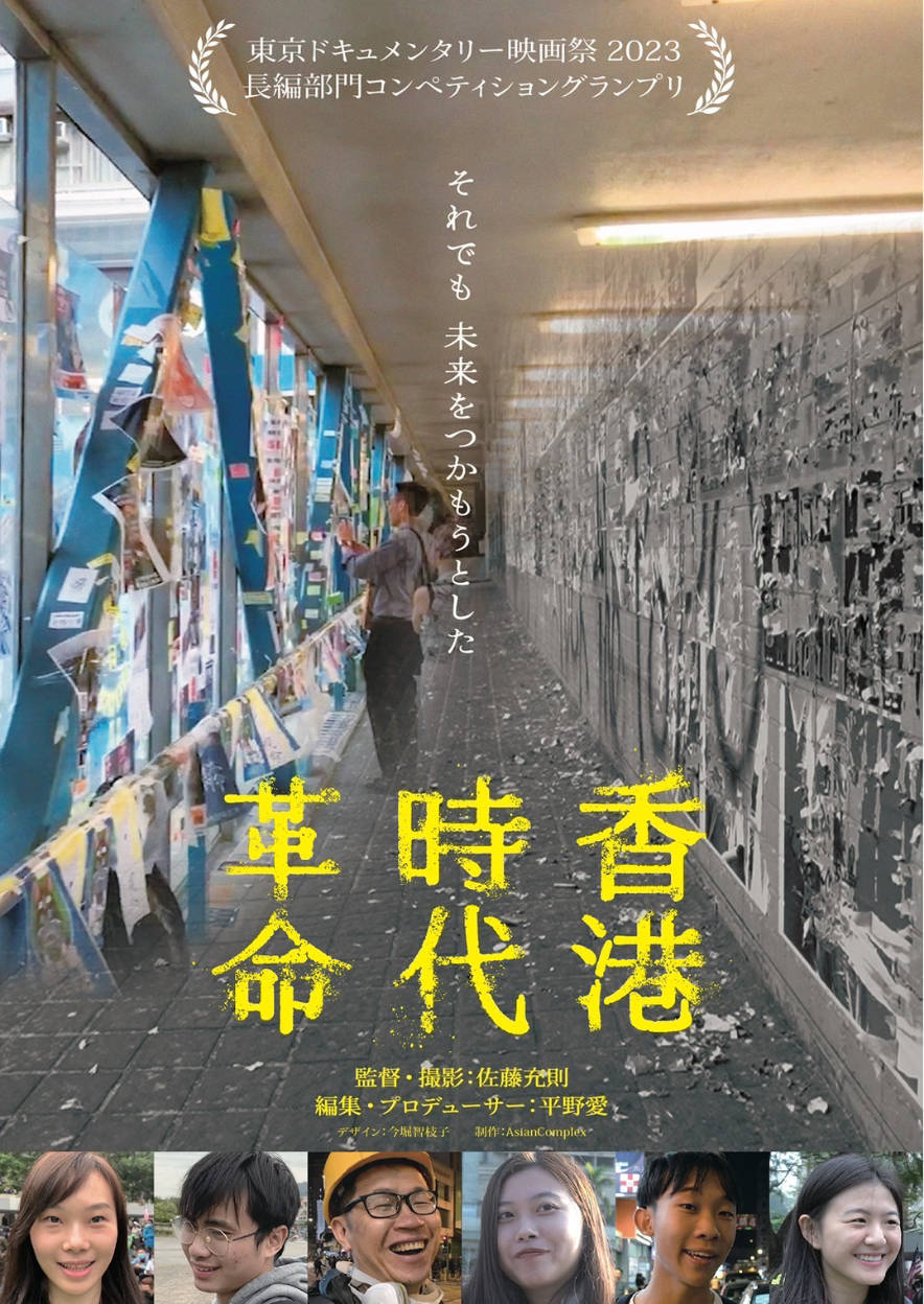 映画『香港時代革命』のポスター。カラフルな連絡通路の壁に貼られたメッセージや写真の前に立つ人の姿。中央には「それでも未来をつかもうとした」というコピーと、黄色い文字で「香港時代革命」と書かれている。下部には監督・撮影：佐藤充則、編集・プロデューサー：平野愛の記載と6人の人物の笑顔の写真が並ぶ。